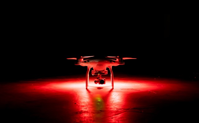 an image of a drone in the dark, with red light surrounding it