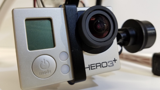 a close up photo of a gopro camera, attached to the gimbal of a cheap drone